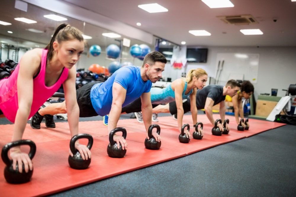 People doing strengthening exercises in fitness class at the gym